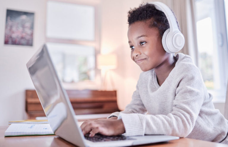 Shot of a young boy doing his homework on a laptop at home